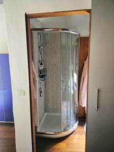 cabina doccia in una stanza con porta in vetro di Atelier di Carlo a Monticiano