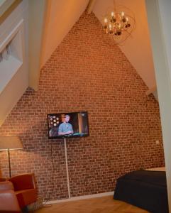 a living room filled with furniture and a television at Hotel de Tabaksplant in Amersfoort
