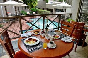 a wooden table with breakfast food on a balcony at Courtyard Hotel Sandton in Johannesburg
