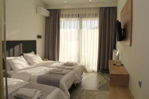 a hotel room with two beds and a window at Alexiou Hotel in Kalabaka