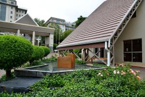 a building with a roof with a bench and a suitcase at Courtyard Hotel Sandton in Johannesburg