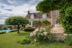Vouneuil-sur-VienneにあるChambres d'Hôtes La Pocterieの庭園とスイミングプール付きの家