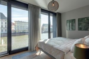 a bedroom with a large window overlooking a river at EXCLUSIVE Aparthotel MARINA in Wrocław