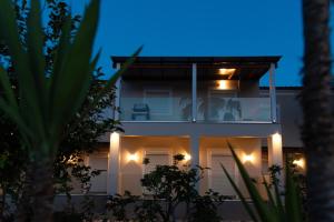 uma casa com luzes de lado à noite em Christa Luxury Apartments em Kavos