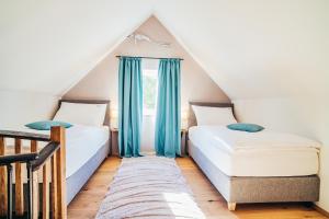 2 camas en un dormitorio en el ático con cortinas azules en Wachau-Living en Dürnstein