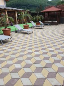 a patio with lounge chairs and a geometric floor at Casa Piri in Anina