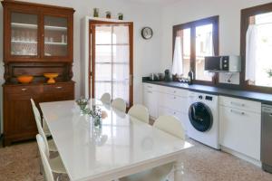 a kitchen with a white table and white appliances at I MONTI SIGNORI in Porto Ota +24 photos
