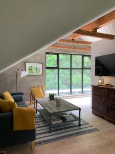 a living room with a couch and a table at Tree Top Hill - The Old Station House - Båstad Holiday Apartments in Båstad