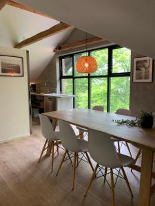 a dining room with a large wooden table and chairs at Tree Top Hill - The Old Station House - Båstad Holiday Apartments in Båstad