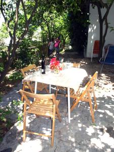 stół i krzesła z kwiatami i butelką wina w obiekcie Apartment Filka w mieście Jelsa