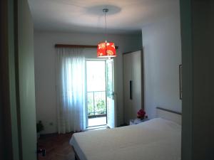 sypialnia z łóżkiem, oknem i żyrandolem w obiekcie Apartment Filka w mieście Jelsa