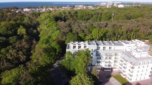 an aerial view of a white building in the woods at Apartamenty Świnoujście - Wyspiańskiego 34e in Świnoujście