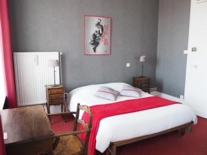 ein Schlafzimmer mit einem Bett mit einer roten Decke in der Unterkunft Hôtel La Villa Lorraine in Toul