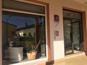 ein Fenster eines Ladens mit einer Topfpflanze darin in der Unterkunft Brit Hotel Europ Bergerac in Bergerac