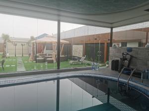 a swimming pool with a gazebo and a house at Alreem challet in Abha