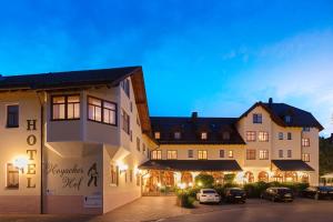 eine Gruppe von Gebäuden mit Autos auf einem Parkplatz in der Unterkunft Hotel Hoyacker Hof in Garching bei München