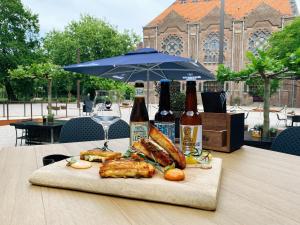 a plate of food on a table with bottles of beer at Hotel Mariënhage in Eindhoven