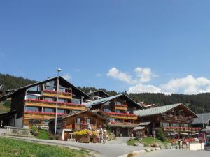 a building with balconies on the side of a mountain at Hôtel Le Very in Les Saisies