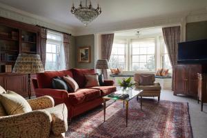 a living room with a red couch and chairs at The Gleneagles Hotel in Auchterarder