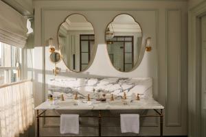 a bathroom with two sinks and two mirrors at The Gleneagles Hotel in Auchterarder
