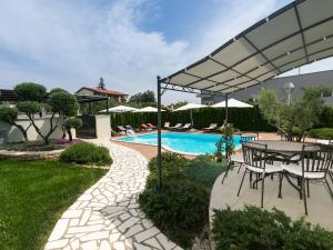 una piscina con tavolo e sedie e un patio di Villa Birikina with Pool a Poreč (Parenzo)