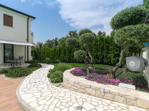 a garden with a stone walkway and purple flowers at Villa Birikina with Pool in Poreč