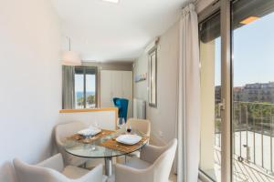 een eetkamer met een glazen tafel en witte stoelen bij Kronos on the Beach Attic Suite in Barcelona