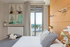 een slaapkamer met een bed met uitzicht op de oceaan bij Kronos on the Beach Attic Suite in Barcelona