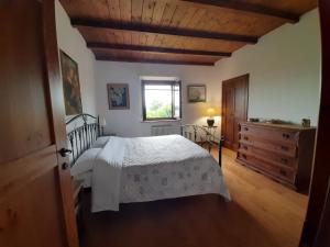 um quarto com uma cama branca e um tecto de madeira em La confluenza casa vacanze em Osimo