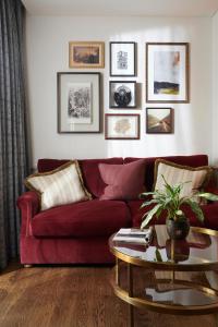 a living room with a red couch and a table at The Gleneagles Hotel in Auchterarder