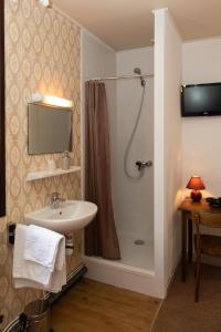 a bathroom with a sink and a shower at Hôtel de la Mairie in LʼArgentière-la-Bessée