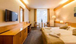 um quarto de hotel com duas camas e uma televisão de ecrã plano em Aqua Hotel Termál em Mosonmagyaróvár