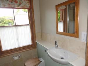a bathroom with a sink and a toilet and a mirror at Wyndham Park Lodge in Salisbury
