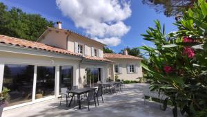 a patio with a black table and chairs at La Villa Moursoise 4 Etoiles in Mours-Saint-EusÃ¨be