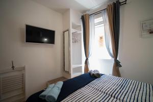 1 dormitorio con 1 cama y TV en la pared en Stelle D'oro, en Rovinj