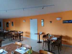 a dining room with wooden tables and chairs at Hôtel Bar des Arènes in Pontonx-sur-lʼAdour