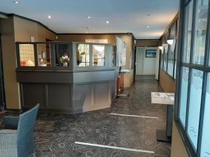 a hallway of a building with a lobby with a reception desk at Hôtel Restaurant du Lac in Combourg