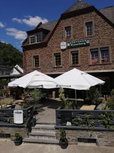 a restaurant with umbrellas in front of a building at Gasthaus Rosenberg in Klotten