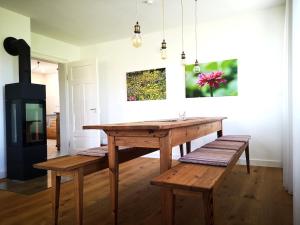 comedor con mesa de madera y bancos en Ferienhaus Nordschwarzwald, en Neuweiler