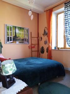 a bedroom with a blue bed and a window at Le champ des étoiles in Massoulès