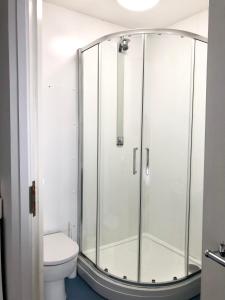 a glass shower in a bathroom with a toilet at FSC Millport Hostel in Millport