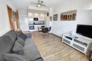 uma sala de estar com um sofá e uma televisão de ecrã plano em Benal Beach, Luxury Sea & Mountain View Beachside 1 Bedroom Apartment em Benalmádena