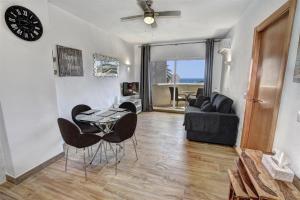 sala de estar con mesa, sillas y sofá en Benal Beach, Luxury Sea & Mountain View Beachside 1 Bedroom Apartment, en Benalmádena