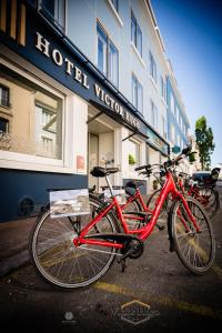 ein vor einem Geschäft geparkt rotes Fahrrad in der Unterkunft Hôtel Victor Hugo Lorient in Lorient