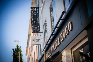 un cartello per un ristorante sul lato di un edificio di Hôtel Victor Hugo Lorient a Lorient