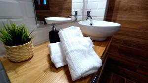 a bathroom with a white sink and a white towels at APARTAMENTOS EL POZO AMARGO in Toledo