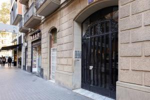 巴塞隆納的住宿－Piso nuevo al lado de la Sagrada Familia.，街道边有黑色门的建筑物
