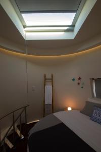 a bedroom with a bed and a light on the ceiling at Wellshouses in Capelas