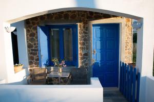 a blue door and a table in front of a house at Milatos Studios in Milatos