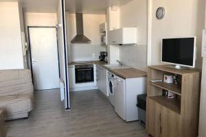 a small apartment kitchen with a television and a counter at La Fayette 2*, Meublé tout confort avec vue sur le port in Rochefort